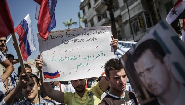 Homem segura o cartaz que diz Obrigado, Rússia, que restaurou o equilíbrio no mundo durante a manifestação na Síria em apoio da Rússia (foto de arquivo) - Sputnik Brasil
