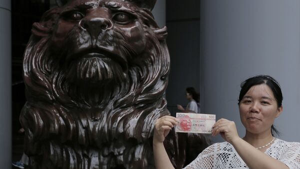 Mulher segura cédula de dólar de Hong Kong diante de estátua de leão, símbolo da cidade - Sputnik Brasil