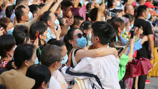 Mulher abraça estudante durante formatura de estudantes em Wuhan, epicentro da COVID-19 na China - Sputnik Brasil
