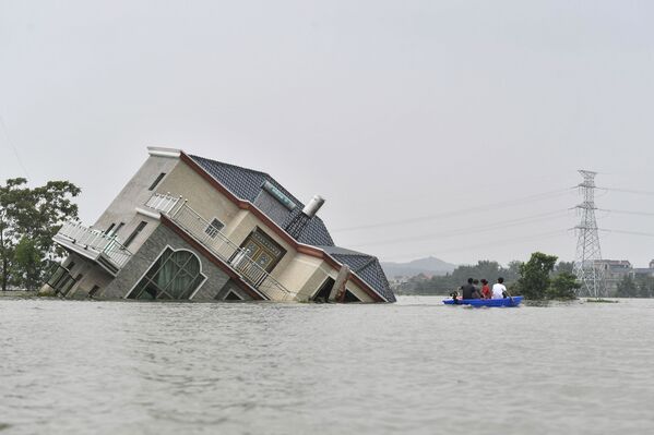 Casa tombada e inundada após chuvas torrenciais terem atingido o condado de Poyang, na China - Sputnik Brasil