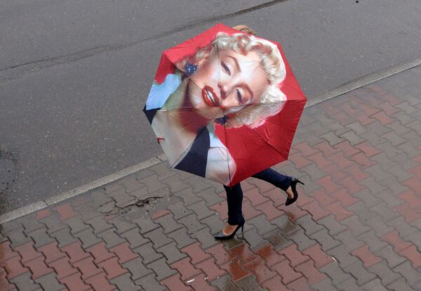 Mulher usa guarda-chuva com imagem da atriz americana Marylin Monroe na cidade russa de Krasnoyarsk - Sputnik Brasil