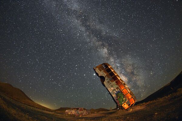 Ônibus é visto em zona de veículos abandonados no estado americano do Nevada, tendo ao fundo o esplendor da Via Láctea - Sputnik Brasil