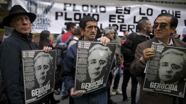 Em Bogotá, manifestantes contrários a Álvaro Uribe seguram cartazes durante protesto contra o político em frente à Suprema Corte, durante uma audiência de investigação tendo como réu o ex-presidente da Colômbia, em 8 de outubro de 2019 - Sputnik Brasil
