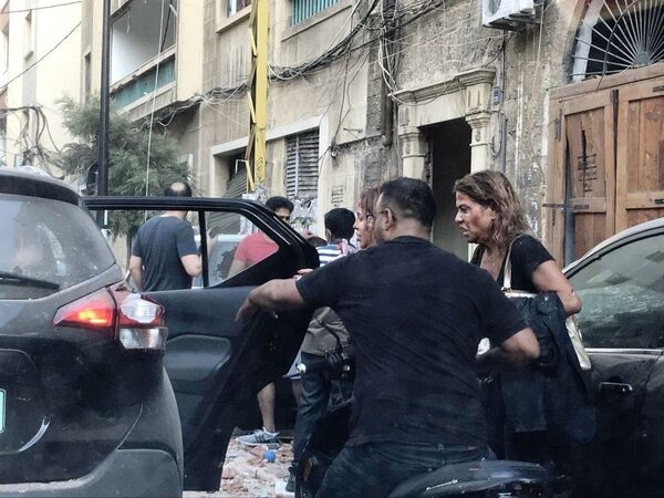 Pessoas feridas por fragmentos de vitrines são socorridas após uma explosão perto do porto de Beirute - Sputnik Brasil