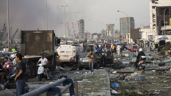 Em Beirute, pessoas circulam entre carros e destroços em rodovia após forte explosão na zona portuária da capital libanesa que causou destruição pela cidade, em 4 de agosto de 2020. - Sputnik Brasil