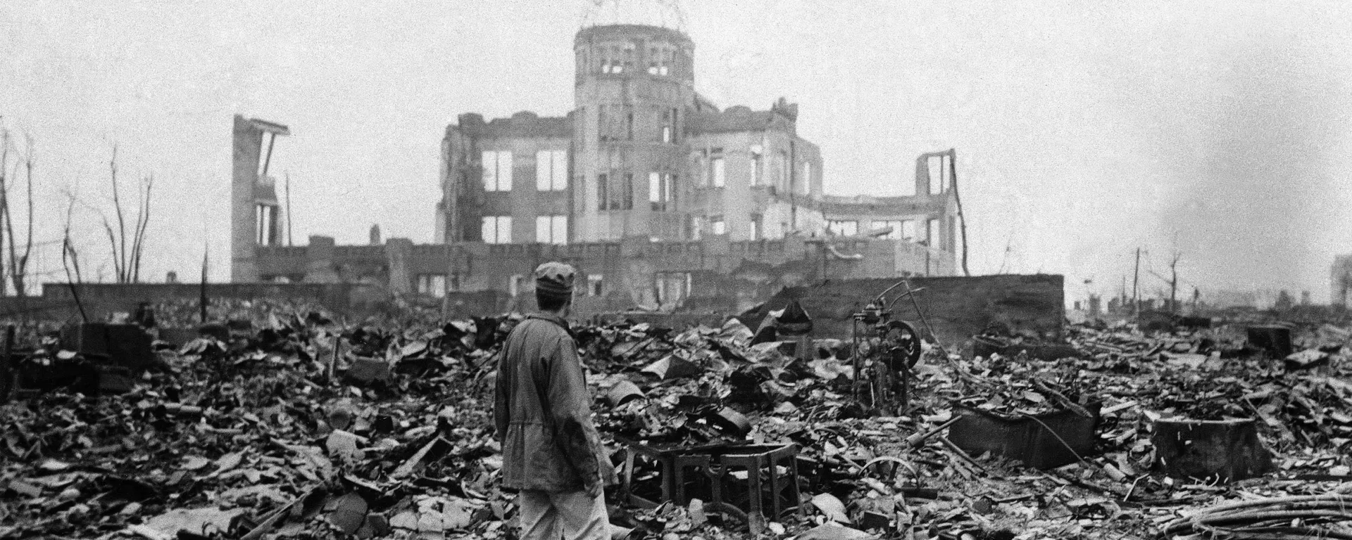Foto de arquivo: um correspondente aliado está em um mar de escombros diante das ruínas de um prédio que antigamente era um cinema em Hiroshima, em 8 de setembro de 1945, um mês após a primeira bomba atômica usada em guerra ter sido lançada pelos EUA para acelerar a rendição do Japão - Sputnik Brasil, 1920, 06.08.2025