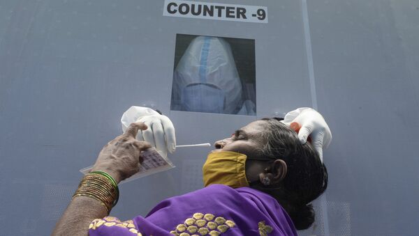 Mulher faz teste da COVID-19 em ponto de atendimento em Hyderabad, Índia - Sputnik Brasil