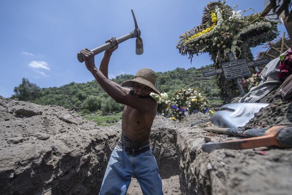 Coveiro abrindo nova cova durante funeral no cemitério San Miguel Xico, no México, durante a pandemia da COVID-19 Coveiro abrindo nova cova durante funeral no cemitério San Miguel Xico, no México, durante a pandemia da COVID-19 - Sputnik Brasil