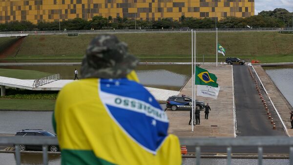 Manifestante repudia hasteamento a meio-mastro de bandeira nacional em frente ao Congresso como luto pela 100 mil vítimas do novo coronavírus - Sputnik Brasil