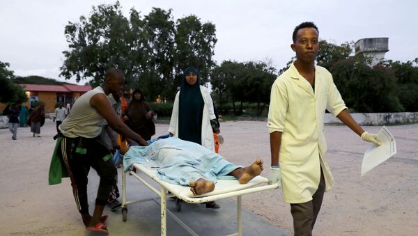 Em Mogadíscio, capital da Somália, equipe médica e civis carregam uma pessoa ferida após uma explosão de carro-bomba em hotel de luxo na praia de Lido, em 16 de agosto de 2020. - Sputnik Brasil