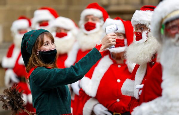 Mulher vestida de elfo posa para uma foto com os graduados da Escola de Papai Noel da Ministry of Fun em Londres - Sputnik Brasil