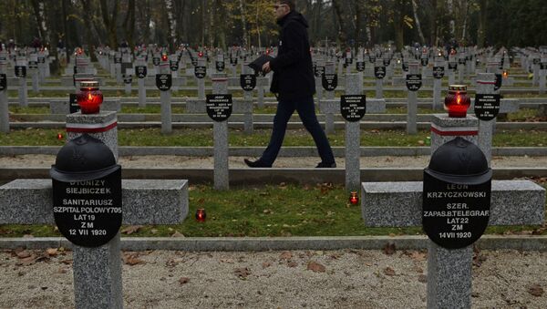 Homem passa diante de cemitério dedicado a soldados poloneses - Sputnik Brasil