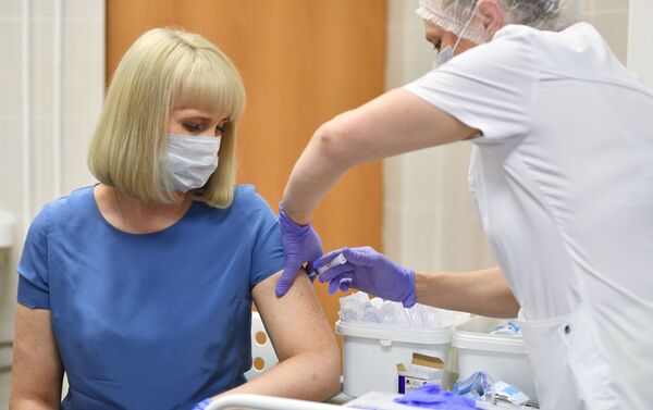 Voluntária toma a vacina Sputnik V durante testes clínicos pós-registro do medicamento em Moscou - Sputnik Brasil