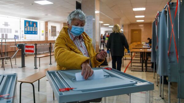 Em Tomsk, na Rússia, uma mulher deposita seu voto durante eleições locais, em 13 de setembro de 2020. - Sputnik Brasil
