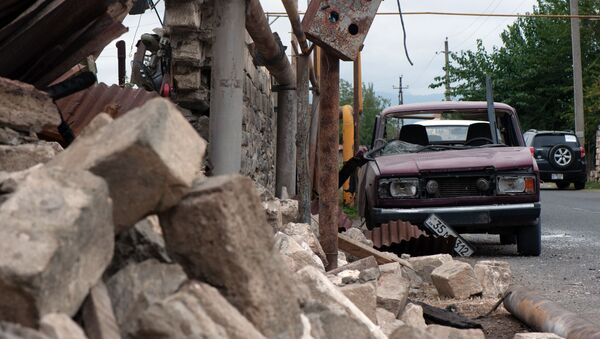 Casa e carro destruídos na sequência de bombardeamento de uma povoação em Nagorno-Karabakh - Sputnik Brasil