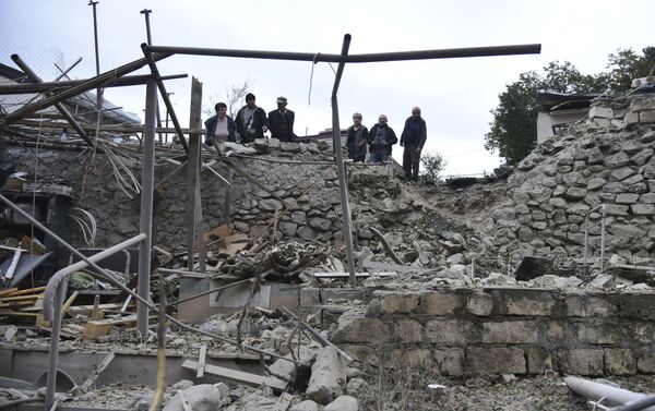 Homens observam destruição em Stepanakert, na república não reconhecida de Nagorno-Karabakh, após ataques de artilharia - Sputnik Brasil