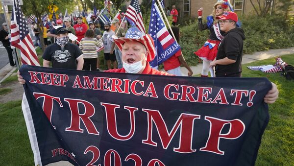 Homem segura cartaz em apoio à reeleição de Donald Trump - Sputnik Brasil