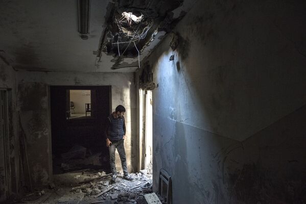 Homem passa por casa, afetada por bombardeio das Forças Armadas do Azerbaijão, na cidade de Shusha - Sputnik Brasil
