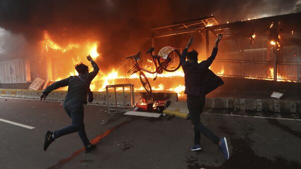 Em Jacarta, manifestantes jogam bicicletas em uma estação de metrô em chamas durante protesto na capital da Indonésia, em 8 de outubro de 2020 - Sputnik Brasil