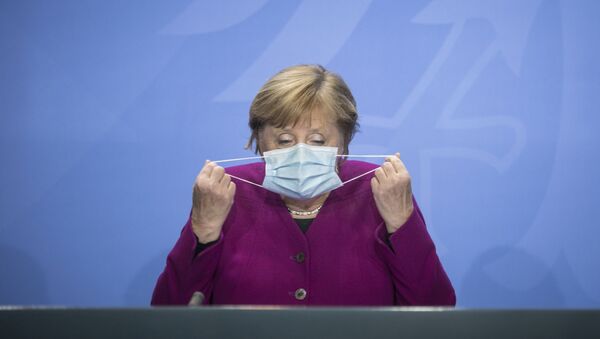 Em Berlim, a chanceler alemã Angela Merkel manuseia sua máscara na chegada a uma coletiva de imprensa após encontro com governadores estaduais do país, em 14 de outubro de 2020 - Sputnik Brasil