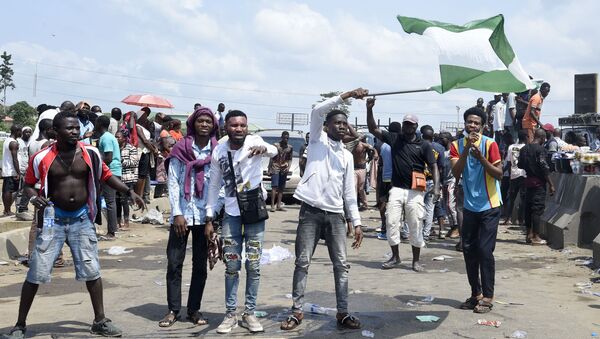 Manifestantes exibem a bandeira da Nigéria em Lagos durante protesto contra violência policial - Sputnik Brasil