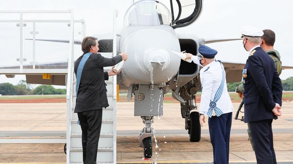 O presidente  Jair Bolsonaro batiza o F-39E Gripen com champanhe ao lado o comandante da Aeronáutica, Antônio Carlos Moretti Bermudez. - Sputnik Brasil