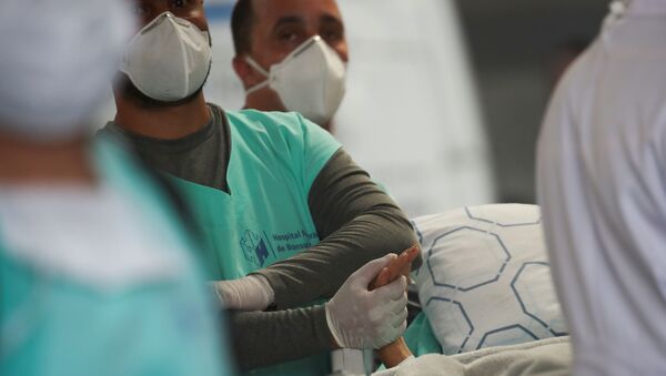 Profissional de saúde segura mão de paciente durante evacuação do Hospital Federal de Bonsucesso, no Rio de Janeiro, 27 de outubro de 2020  - Sputnik Brasil