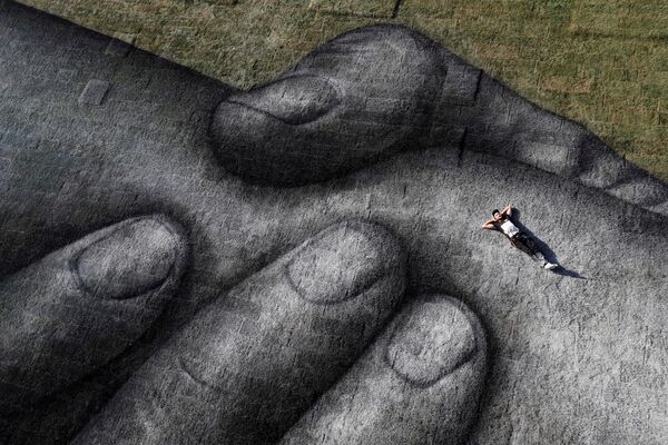 Artista de rua franco-suíço Saype posa deitado em uma de suas obras em Istambul - Sputnik Brasil