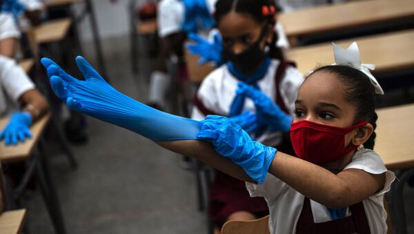 Aluna usa máscara e luvas em uma escola de Havana, Cuba - Sputnik Brasil