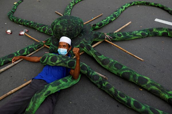Pescador com máscara se deita no chão com um polvo artificial durante protesto contra reforma trabalhista em Jacarta, Indonésia, 10 de novembro de 2020 - Sputnik Brasil