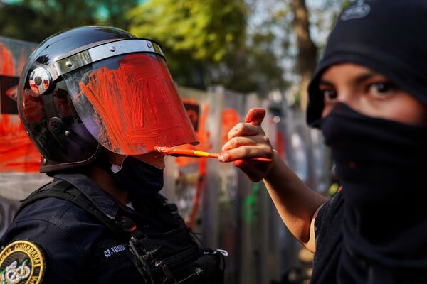 Ativista feminista pinta capacete de policial durante ato contra violência de gênero e policial, Cidade do México, México - Sputnik Brasil