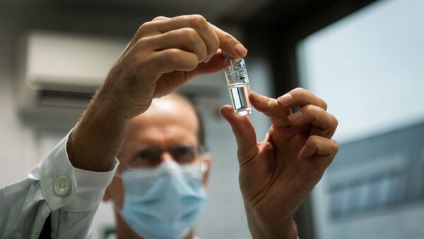 Assistente de laboratório segurando tubo com vacina russa Sputnik V - Sputnik Brasil