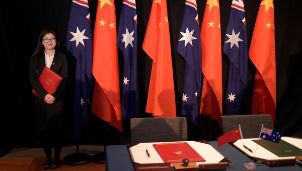 Mulher segura uma cópia do Tratado de Livre Comércio (TLC) ao lado das bandeiras nacionais da China e da Austrália - Sputnik Brasil
