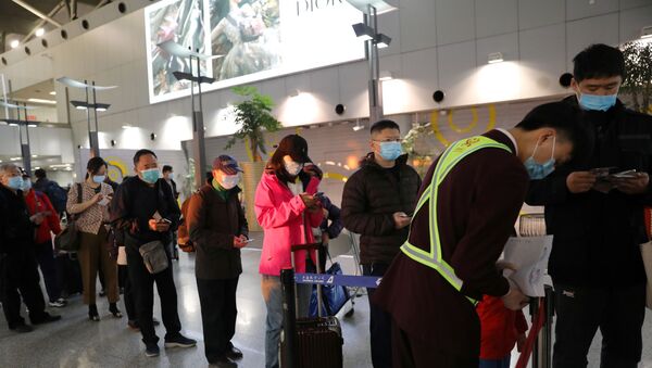 Passageiros e funcionários com máscaras contra coronavírus em aeroporto da China - Sputnik Brasil