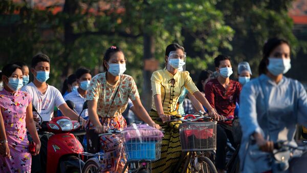 Pessoas usando máscaras andam de bicicleta na rua durante o surto de coronavírus em Yangon, Mianmar, 7 de dezembro de 2020 - Sputnik Brasil
