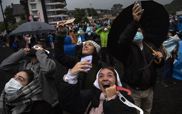 Pessoas observam o eclipse solar total em bancos do lago Villarrica, Chile, 14 de dezembro 2020. Centenas de turistas e moradores do sul do Chile esperavam ver o eclipse, mas uma chuva atrapalhou seus planos - Sputnik Brasil