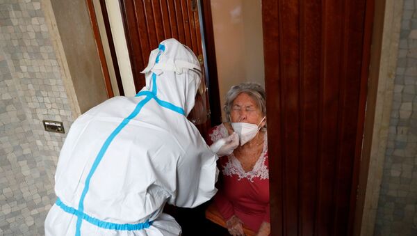 Profissional da saúde fazendo atendimento domiciliar a uma idosa suspeita de ter contraído a COVID-19 em Roma, Itália, no dia 3 de dezembro de 2020 - Sputnik Brasil
