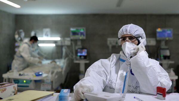 Enfermeira que cura pacientes com COVID-19 fala ao telefone em hospital de Teerã, Irã, 16 de dezembro de 2020 - Sputnik Brasil