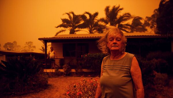 Casal australiano em frente à sua residência, conforme o vento traz chamas e cinzas, durante incêndios florestais na Austrália, 4 de janeiro de 2020 - Sputnik Brasil