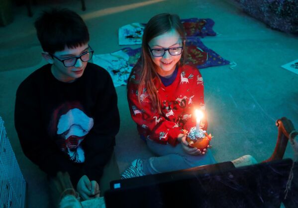 Crianças durante transmissão on-line do Christingle na véspera de Natal, Blakesley, Reino Unido, 24 de dezembro de 2020 - Sputnik Brasil