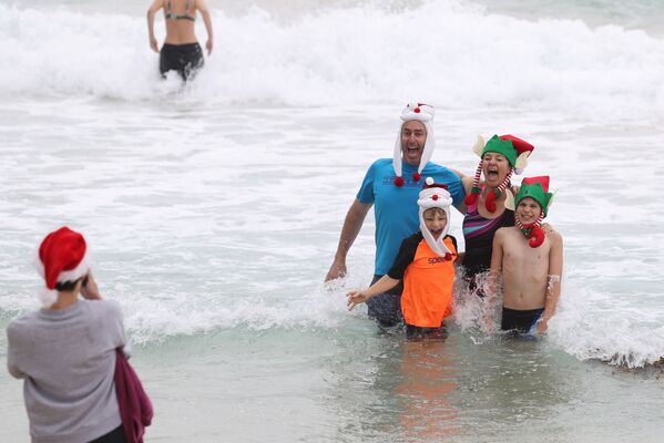 Vestindo gorros natalinos, banhistas marcaram presença na praia Bondi de Sydney, na Austrália, 25 de dezembro de 2020 - Sputnik Brasil
