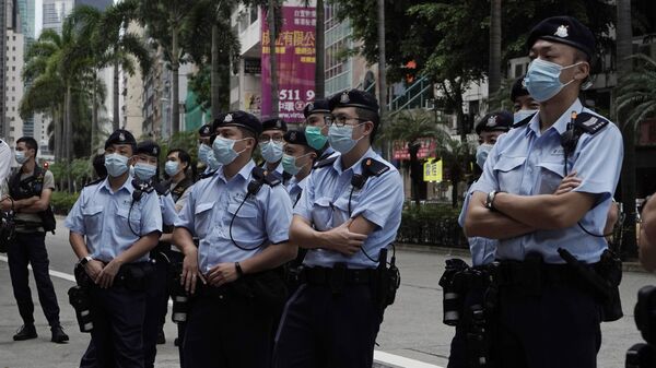 Policiais ficam de guarda enquanto ativistas pró-democracia marcham em Hong Kong, em 1º de outubro de 2020 - Sputnik Brasil