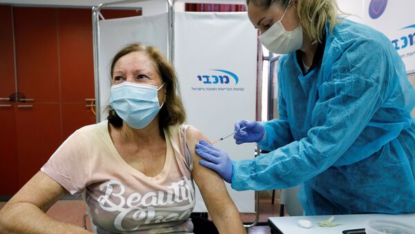Uma israelense recebe a vacina contra a COVID-19 na cidade de Ashdod em 29 de dezembro de 2020 - Sputnik Brasil