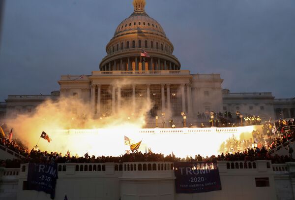 Explosão causada por uma munição da polícia enquanto apoiadores de Donald Trump se reúnem em frente ao edifício do Capitólio dos Estados Unidos em Washington, EUA, 6 de janeiro de 2021 - Sputnik Brasil