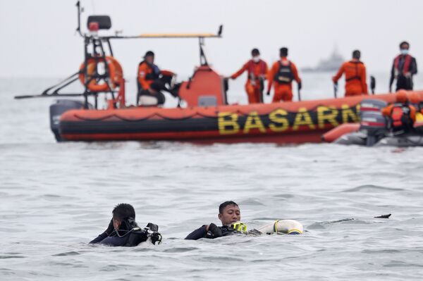 Mergulhadores da Marinha da Indonésia coletam destroços do avião de passageiros durante as operações de busca e salvamento
 - Sputnik Brasil