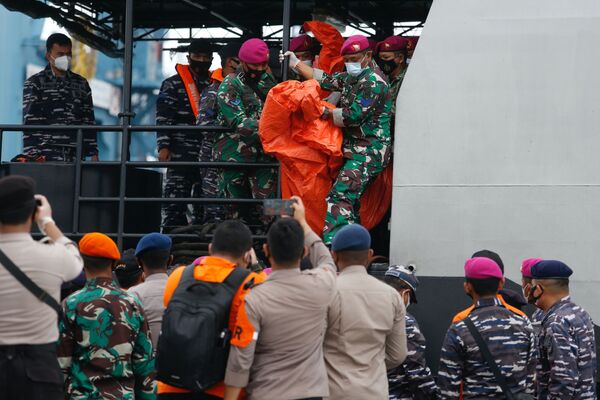 Equipe de resgate carrega o que se acredita serem destroços do avião da Sriwijaya Air
 - Sputnik Brasil