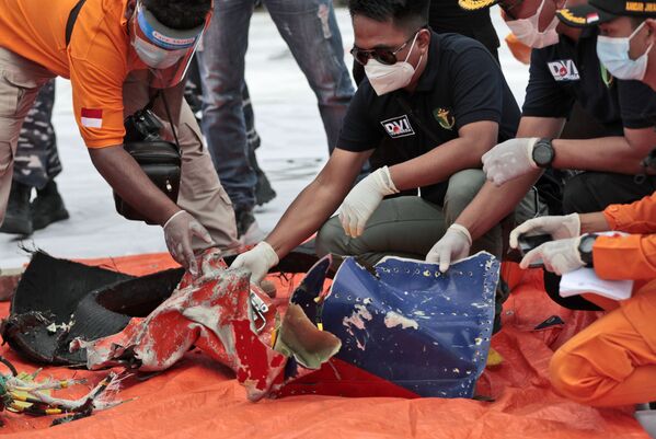 Investigadores inspecionam os destroços encontrados no mar ao largo da ilha de Java
 - Sputnik Brasil