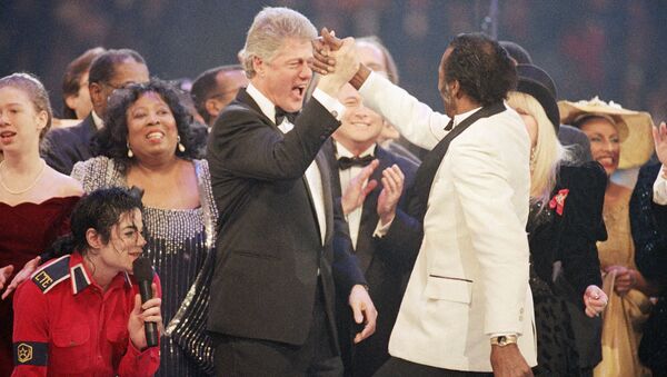 Presidente eleito Bill Clinton, à esquerda ao centro, dá um toque de cumprimento a Chuck Berry, à direita, durante o final da Gala Presidencial no Capital Centre em Landover, estado de Maryland, Estados Unidos, 19 de janeiro de 1993. À esquerda estão Michael Jackson, agachado, e Chelsea Clinton - Sputnik Brasil