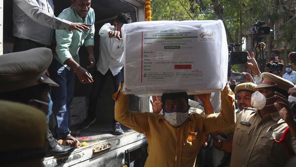 Em Hyderabad, na Índia, em meio à preparação para a campanha de imunização no país asiático, profissionais de saúde desembarcam caixas com a vacina contra a COVID-19, em 12 de janeiro de 2021 - Sputnik Brasil