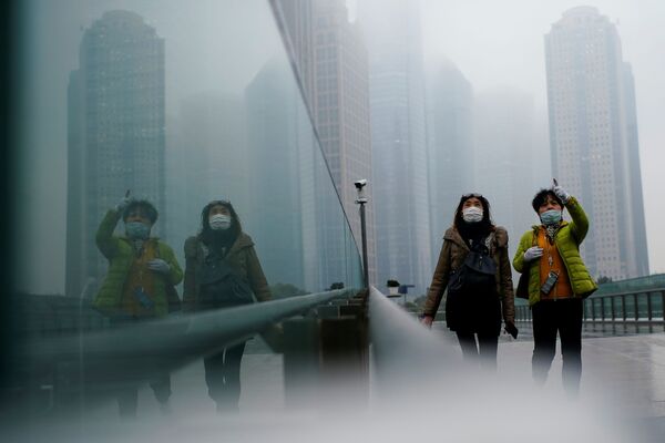 Pessoas com máscaras andam pela rua durante a pandemia, Shanghai, China, 26 de janeiro de 2021 - Sputnik Brasil